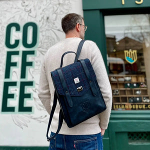 A man wearing a navy over-check Islander Carloway backpack.