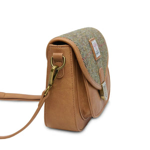 Side image of the Chestnut Herringbone Harris Tweed Mini Saddle Bag showing the depth of the bag and also where the shoulder strap attaches.