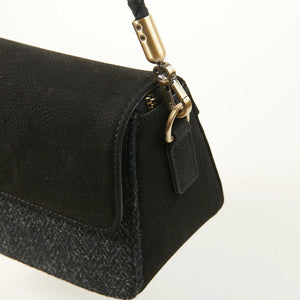 Close-up of brass hardware and braided strap attachment on the Caithness Clutch Bag, highlighting the textured black leather and quality metal finish.