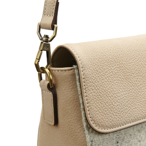 Detail of the clasp and stitching on the Islander Caithness Harris Tweed Clutch Bag in cream leather.