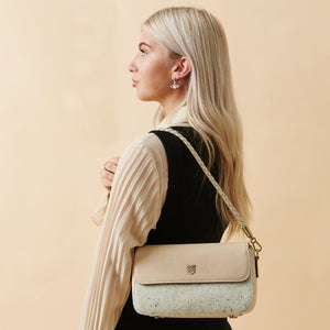 Model wearing the Islander Caithness Harris Tweed Clutch Bag in cream leather, highlighting its elegant and compact design.