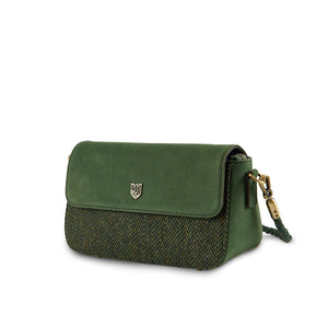 Angled view of the Islander Caithness Harris Tweed Clutch Bag in dark green herringbone tweed with premium green leather trim.