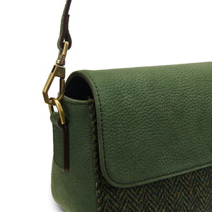 Close-up of the gold clasp and green leather strap on the Islander Caithness Harris Tweed Clutch Bag in dark green herringbone.