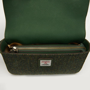 Interior view of the Islander Caithness Harris Tweed Clutch Bag in dark green herringbone, showing zippered pockets and Harris Tweed label.