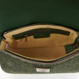 Interior view of the Islander Caithness Harris Tweed Clutch Bag in dark green herringbone, showing zippered pockets and Harris Tweed label.