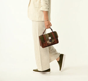 Lady holding the chestnut brown tartan satchel from the top strap.