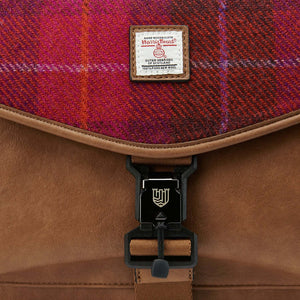 A close-up of the red tartan Harris Tweed fabric and the closing buckle on a laptop case.