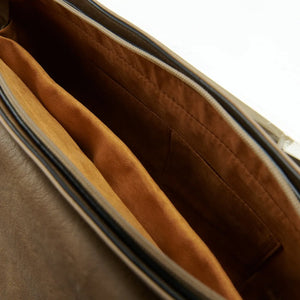 Close-up view of the inside of a red tartan Harris Tweed laptop case, showcasing the interior lining and compartments.