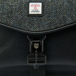 A close-up of the black herringbone Harris Tweed fabric used in the Islander Harris Tweed laptop case, highlighting its intricate weave and texture.