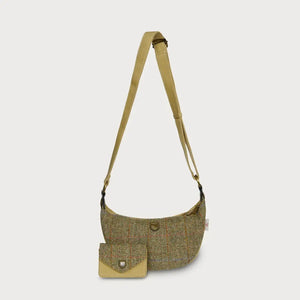 A chestnut herringbone Harris Tweed Luna bag with a matching purse sitting in front of it, on a white background.