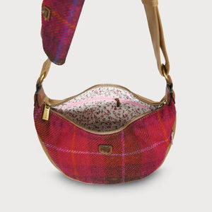 A close-up of the inside of a red tartan Harris Tweed Luna bag, showing a lined interior with pockets.