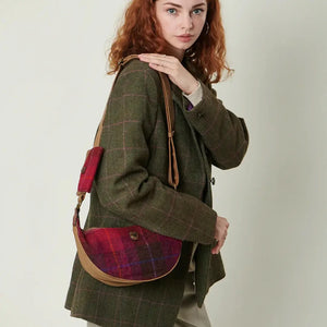  A woman with red hair is carrying a red tartan Islander Harris Tweed Luna bag.