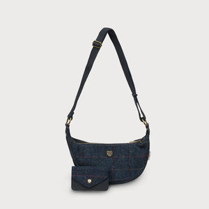 A navy over-check Harris Tweed Luna bag with a matching purse sitting in front of it, on a white background.