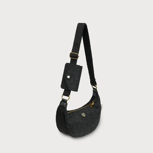 A side view of a black herringbone Harris Tweed Luna bag on a white background.