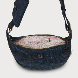 A close-up of the inside of a navy over-check Harris Tweed Luna bag, showing a lined interior with pockets.