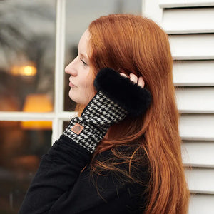 A woman wearing cozy Islander Ladies Lambswool Mittens in Black and White Dogtooth, perfect for staying warm in cold weather.