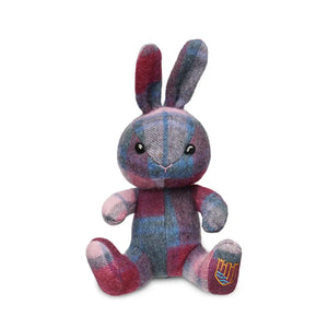 A pink and blue Islander tartan lambswool bunny sitting upright with its ears perked up.