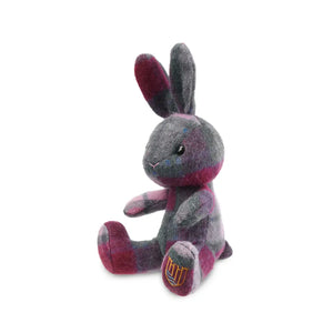 A pink and blue Islander tartan lambswool bunny viewed from the side, showcasing its soft fur and floppy ears.