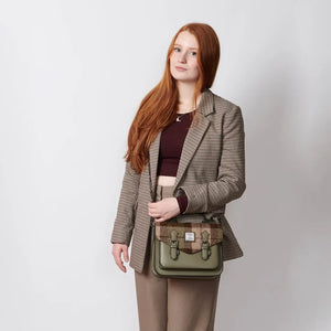 A woman is seen wearing a stylish chestnut tartan satchel bag, effortlessly complementing her outfit.