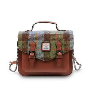 A chestnut and blue tartan Harris Tweed satchel bag with a metal chain shoulder strap discreetly positioned behind the bag.