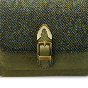 A close-up of the green Harris Tweed fabric on a Melrose Leather Crossbody Bag. It shows the intricate weave and pattern of the fabric.