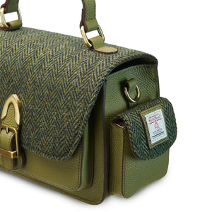 A close-up of the side pocket on a green Harris Tweed Melrose Leather Crossbody Bag. It shows the detail of the pocket and the leather trim.