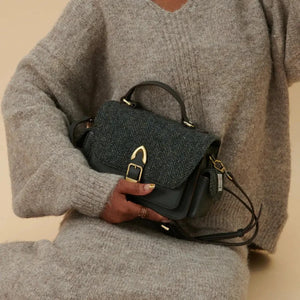 A close-up of the Harris Tweed fabric on a beige Melrose Leather Crossbody Bag. The fabric features a traditional Scottish pattern.