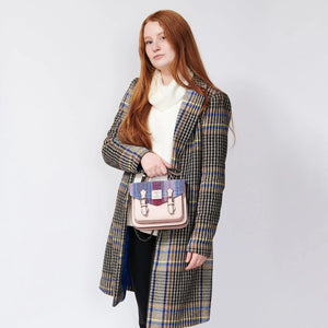 A woman is seen holding a vibrant pink and blue tartan Mini Calton Satchel, highlighting its compact size and stylish design.