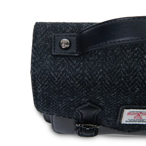 A top-down view of a black herringbone Mini Calton Satchel, highlighting its rectangular shape and Harris Tweed® panel.