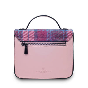 A rear view of a pink and blue tartan Harris Tweed Mini Calton Satchel, displaying its additional pocket and metal chain strap.