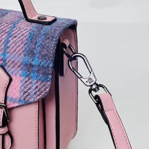 A close-up of the metal chain strap connecting to the pink and blue tartan Harris Tweed Mini Calton Satchel.