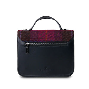 A rear view of a red tartan Harris Tweed Mini Calton Satchel, displaying its additional pocket and metal chain strap.