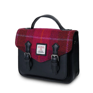 A side view of a bold red tartan Harris Tweed Mini Calton Satchel, showcasing its compact size and adjustable strap.