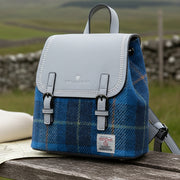 Harris Tweed blue tartan mini backpack on bench in Scottish countryside