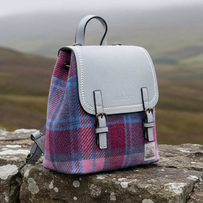 Pink-blue Harris Tweed mini backpack on stone wall in Scottish highlands