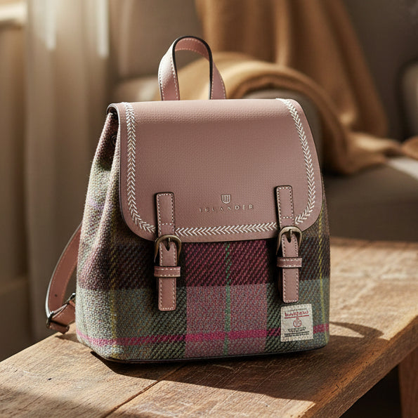 Mini Jura pink-green tartan backpack worn with cream cable-knit sweater outdoors