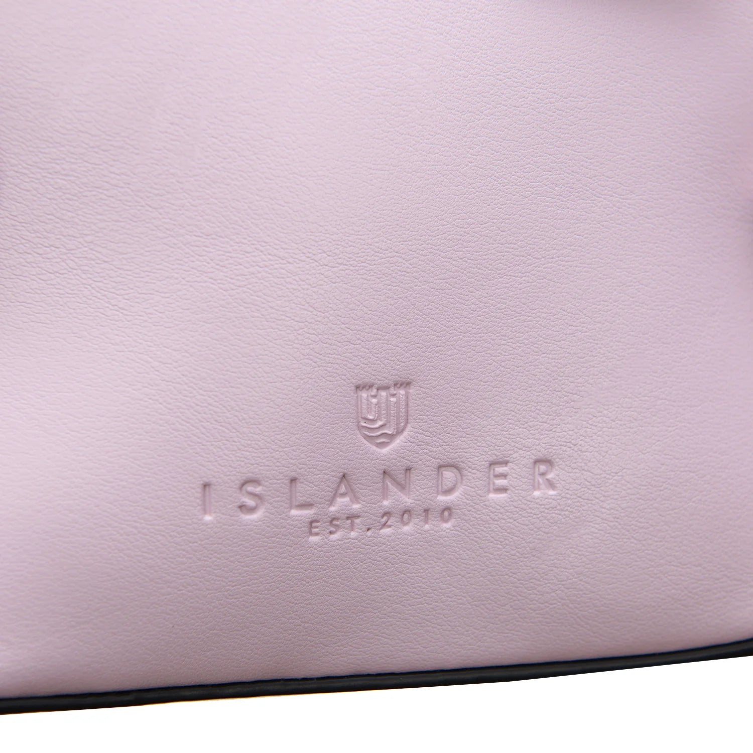 Islander EST 2010 embossed shield logo on violet leather flap close-up