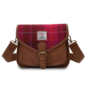 Ladies red tartan Harris Tweed saddle bag with a brown PU leather body and the shoulder strap draped across the back.