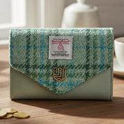 Mint tartan Harris Tweed clasp purse with green leather on wooden surface.