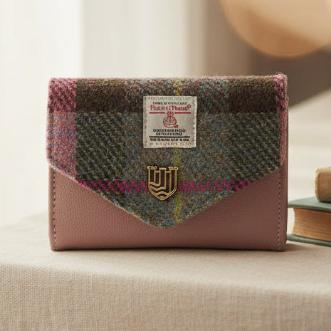 Pink-green tartan Harris Tweed clasp purse on cream linen surface.