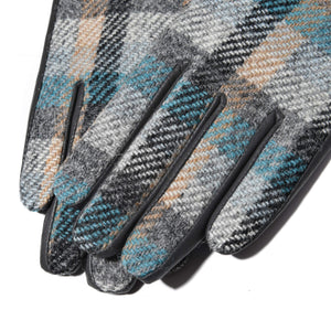 Close-up of fingers on Harris Tweed® Islander tartan gloves, highlighting the intricate wool weave and leather piping detail.