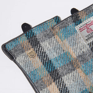 Zoomed-in view of top corner of gloves featuring the Harris Tweed® label and gold crest on the Islander tartan pattern.