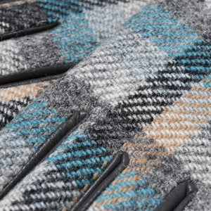 Extreme close-up of wool fabric on Harris Tweed® gloves in Islander tartan, showing texture, colour detail, and leather piping.