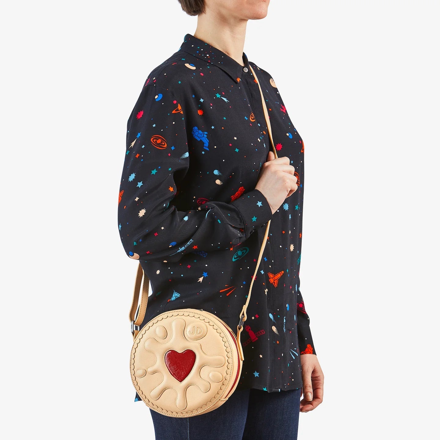 On model – Jammie Dodger cream leather cross body handbag worn over the shoulder with adjustable strap.