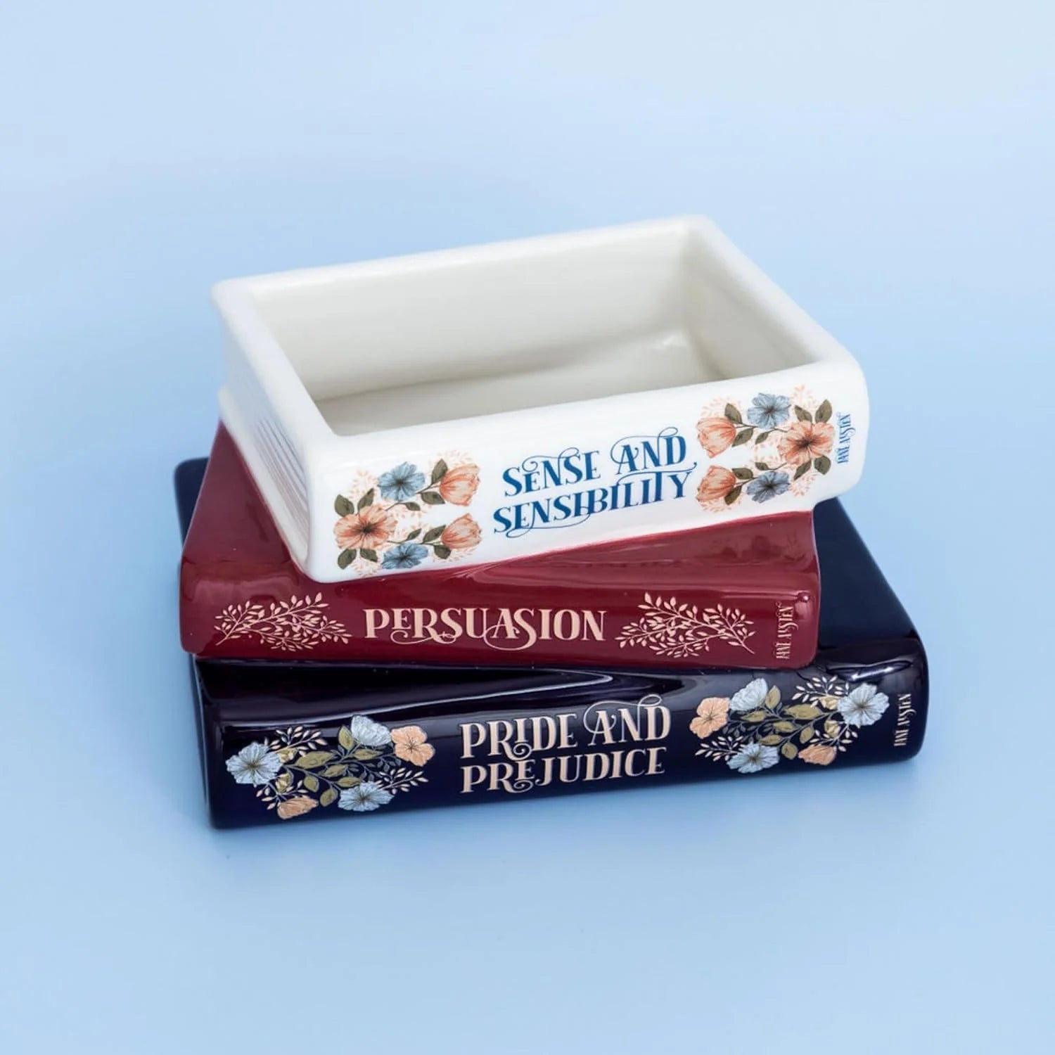 Close-up of the Jane Austen book planter, showcasing elegant typography and intricate floral artwork on each book spine.