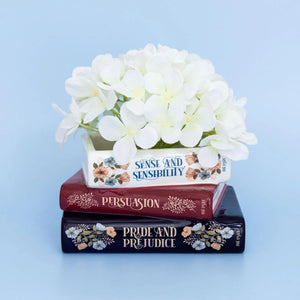 Stacked Books Planter inspired by Jane Austen, styled with white hydrangeas for a charming literary decor touch.