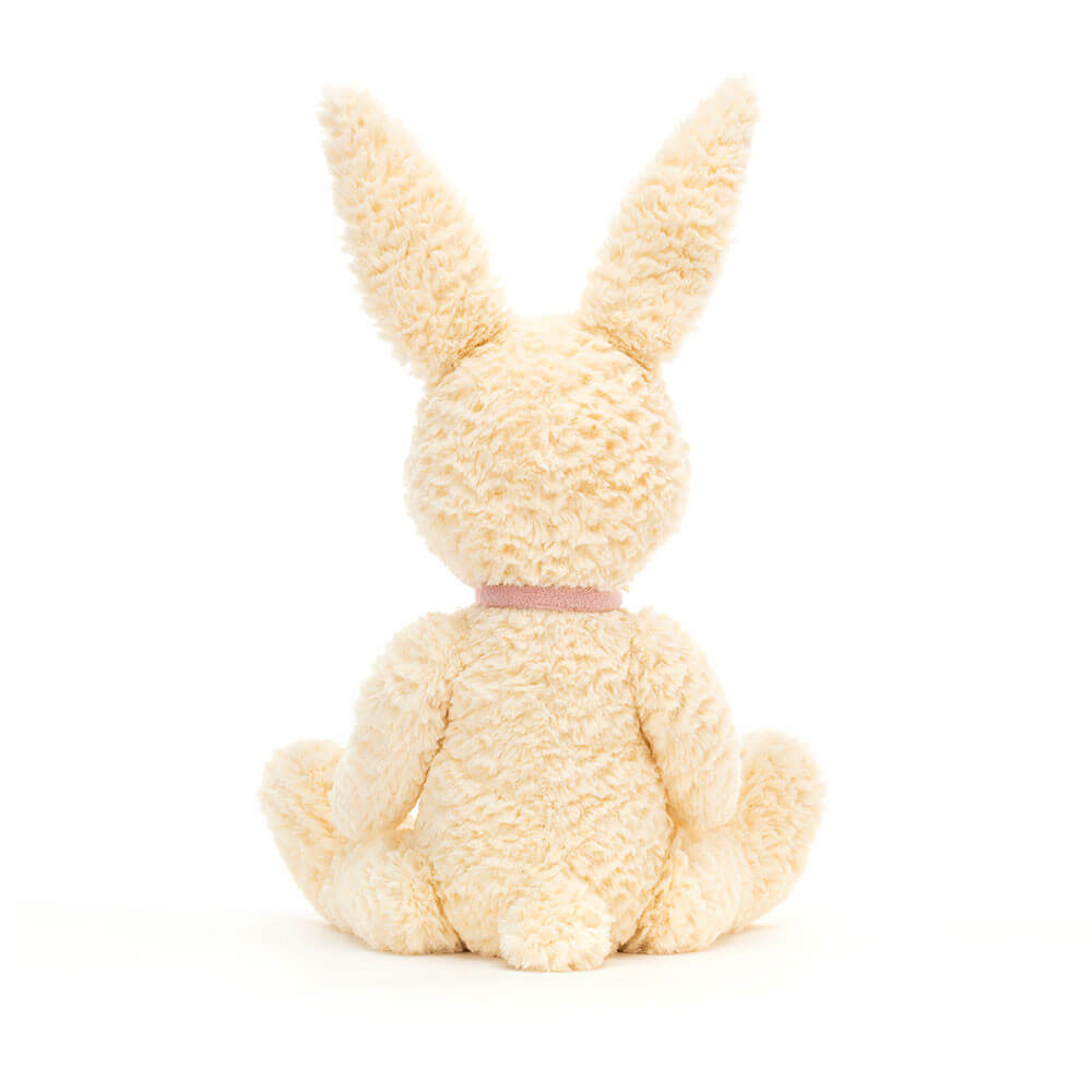The back of a white bunny plush toy. The toy is sitting down and has a fluffy tail. It is made by Jellycat.