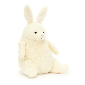 Angled view: Jellycat Amore Bunny at an angle, displaying its textured vanilla fur, charming details like carrot arms and suedette eyelids, and inviting cuddles from all angles.