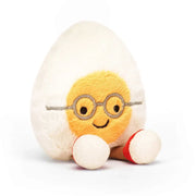 Cream-and-yellow Jellycat Egg Geek plush, turned slightly, showcasing its quirky charm and chocolate cord legs.