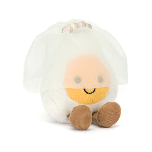 Angled View: Playful Jellycat Amuseable Boiled Egg Bride plush, tilting its head with a charming smile. Sunny yellow yolk and whimsical details visible.